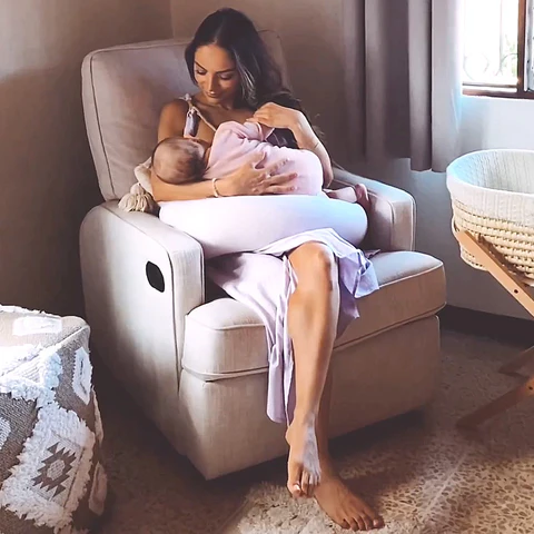 Mother breastfeeding in glider chair, showing comfort and practicality